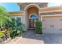 Charming front entrance featuring stone accents, manicured landscaping, and a brick paver walkway at 5439 74Th E Pl, Ellenton, FL 34222