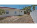 View of the backyard shows the exterior of the home and limited landscaping at 5522 Calle Del Verano, Sarasota, FL 34242