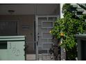 Inviting patio entrance with a unique geometric screen door and lush flowering plants at 600 Manatee Ave # 143, Holmes Beach, FL 34217