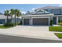 Stunning home with a three-car garage, mature palm trees, and a pristine driveway at 6017 Maidenstone Way, Palmetto, FL 34221