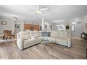 Bright living room with hardwood floors, a comfortable sofa, and an open layout leading to the kitchen at 7424 Arrowhead Run, Lakewood Ranch, FL 34202