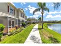 Picturesque backyard featuring a screened patio, lush landscaping, and tranquil water views at 7593 Plantation Cir, Bradenton, FL 34201