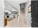 Inviting entryway with a staircase leading upstairs and a modern, open kitchen to the left at 8209 72Nd E St, University Park, FL 34201