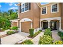 Charming townhouse exterior with a front entrance, manicured landscaping, and an attached garage at 8209 72Nd E St, University Park, FL 34201