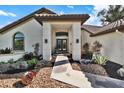 Front entrance with decorative shrubs and an inviting walkway up to the double front doors with sidelight window at 8950 Misty Creek Dr, Sarasota, FL 34241