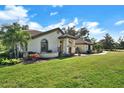 Well-maintained home with a tile roof, arched windows, lush lawn, and landscaped curb appeal at 8950 Misty Creek Dr, Sarasota, FL 34241