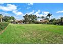 Expansive green lawn with mature trees and landscaping, enhancing the property's privacy and curb appeal at 8950 Misty Creek Dr, Sarasota, FL 34241
