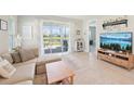 Bright living room with a sliding glass door leading to the screened patio at 9970 Cross River Trl, Parrish, FL 34219