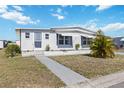 Inviting single-story home featuring a well-maintained lawn, charming facade and blue window awnings at 1005 45Th E Ave, Ellenton, FL 34222