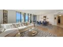 Bright living room featuring hardwood floors, modern furniture, and expansive ocean views through large windows at 1241 Gulf Of Mexico Dr # 803, Longboat Key, FL 34228