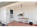 Cozy front porch with tiled flooring, decorative plants, and covered entryway at 1271 Nantucket Rd, Venice, FL 34293