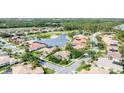 An aerial view of a beautiful residential neighborhood with mature landscaping and beautiful barrel tile roofs at 1311 Tuscany Blvd, Venice, FL 34292