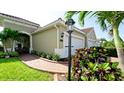 Attractive landscaping with a brick walkway leads to this attached garage home with neutral exterior paint at 1503 Calle Grand St, Bradenton, FL 34209