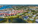 Scenic aerial view of waterfront condos highlighted by a tennis court, lush grass, and tranquil waterways at 1624 Stickney Point Rd # 204, Sarasota, FL 34231