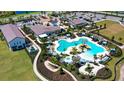 Stunning aerial view of the community pool and recreation center featuring multiple pools, cabanas and lush landscaping at 17119 Barnwood Pl, Bradenton, FL 34211