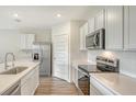 Bright kitchen featuring stainless steel appliances, white cabinets, subway tile backsplash, and quartz countertops at 17119 Barnwood Pl, Bradenton, FL 34211