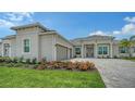 Charming home featuring a brick driveway, well-manicured lawn, attached two-car garage and beautiful landscaping at 17449 Sandpearl Rd, Venice, FL 34293