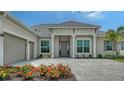 Charming home featuring a brick driveway, well-manicured lawn, attached two-car garage and beautiful landscaping at 17449 Sandpearl Rd, Venice, FL 34293