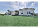 Sprawling backyard featuring well-maintained green lawn and a distant view of neighboring homes and a treeline at 17927 Palmiste Dr, Bradenton, FL 34202