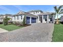 Charming home featuring a manicured lawn, lush plantings, and a spacious driveway leading to a two-car garage at 17927 Palmiste Dr, Bradenton, FL 34202