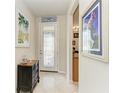 Bright foyer with tiled floors, decorative glass door, and elegant furnishings at 19038 Lappacio St, Venice, FL 34293