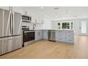 Modern kitchen with stainless steel appliances, stylish gray cabinets, and bright natural light at 2655 Bay St, Sarasota, FL 34237