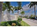 Entrance to University Village, a Medallion Community, with lush landscaping and a stone sign at 2945 Trustee Ave, Sarasota, FL 34243