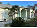 Attractive home showcasing an inviting entrance, columns, manicured plants and an outdoor seating area at 4217 N Chamberlain E Blvd, North Port, FL 34286