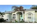 Inviting home with a turquoise front door, arched windows, columns, and a well-manicured lawn at 4217 N Chamberlain E Blvd, North Port, FL 34286