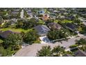 Aerial view of a residential neighborhood with mature trees and a serene lake in the background at 4712 Charles Partin Dr, Parrish, FL 34219