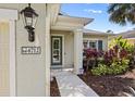 Inviting front entrance featuring a decorative address plaque, a glass-paneled door, and lush landscaping at 4712 Charles Partin Dr, Parrish, FL 34219
