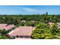 Aerial view of neighborhood featuring tile roofs surrounded by mature trees at 4812 Kestral Park Cir # 20, Sarasota, FL 34231