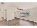 Bright living room with wood-look floors, large windows offering ample natural light, and a modern ceiling fan at 4907 4Th Avenue Nw Cir, Bradenton, FL 34209