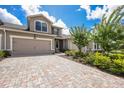 Charming two-story home showcasing a well-manicured lawn and a paved driveway leading to a two-car garage at 5237 Blossom Cv, Lakewood Ranch, FL 34211