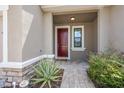 Inviting front porch with a red door, stone accents, and a beautifully landscaped entrance at 5237 Blossom Cv, Lakewood Ranch, FL 34211