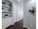 Stylish hallway featuring dark wood floors, built-in shelving, and fresh, neutral paint at 5237 Blossom Cv, Lakewood Ranch, FL 34211