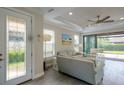 Cozy living room with tray ceilings, ceiling fan, neutral walls and sliding glass door to the lanai at 5301 Bartolomeo St, Sarasota, FL 34238