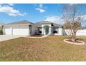 Charming single-story home with a three-car garage, green trim, and landscaped yard at 5909 33Rd E Dr, Palmetto, FL 34221