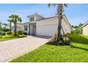 A well-maintained one-story house featuring a brick-paved driveway, a two-car garage, and healthy landscaping at 620 Nasturtium Ct, Nokomis, FL 34275