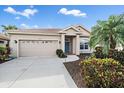 Charming single-story home with lush landscaping and a well-maintained front yard and a two-car garage at 6408 Rookery Cir, Bradenton, FL 34203