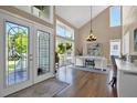 Bright office space with vaulted ceiling, hardwood floors, a modern chandelier, and double door entry at 748 Soundview Dr, Palm Harbor, FL 34683