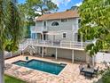 Beautiful backyard pool with a brick paver deck, outdoor dining area, and lush green landscaping at 748 Soundview Dr, Palm Harbor, FL 34683
