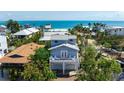 Charming beach house with a balcony, two-car garage, and tropical landscaping at 802 N Bay Blvd, Anna Maria, FL 34216
