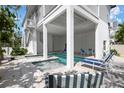 Inviting covered pool area with lounge chairs and outdoor dining space at 802 N Bay Blvd, Anna Maria, FL 34216