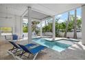 Relaxing pool area with tiled patio, sun loungers, and covered space at 802 N Bay Blvd, Anna Maria, FL 34216