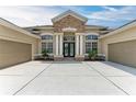 Charming home with a stone facade, double front doors, and a spacious three-car garage at 8103 Snowy Egret Pl, Bradenton, FL 34202