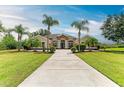 A stunning single-Gathering home featuring a well-manicured lawn and mature palm trees at 8103 Snowy Egret Pl, Bradenton, FL 34202
