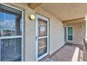 A welcoming front entry door with large windows and a secure screen door, illuminated by a stylish wall sconce at 845 Benjamin Franklin Dr # 302, Sarasota, FL 34236