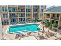 Outdoor pool and patio with chairs and tables at 845 Benjamin Franklin Dr # 302, Sarasota, FL 34236