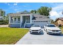 Beautiful home featuring a lush lawn, a covered front porch and a driveway with two stylish vehicles parked out front at 8622 Inwood Dr, Hudson, FL 34667
